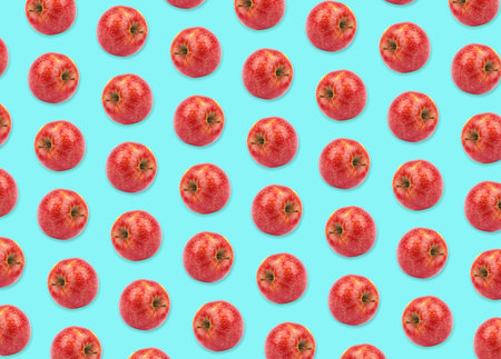 Pattern of red apples on light blue backgroundの写真素材