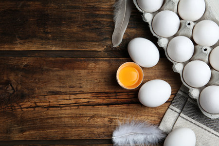 Flat lay composition with fresh raw chicken eggs on wooden table. Space for text