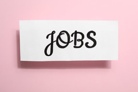 Card with word JOBS on pink background, top view. career conceptの写真素材