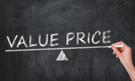 Woman writing phrase VALUE PRICE on blackboard, closeupの写真素材