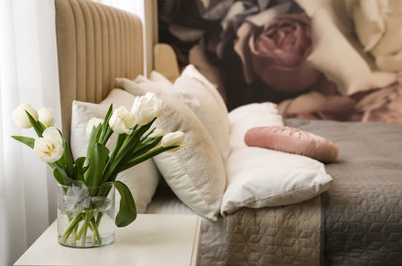 Vase with white tulips on table in bedroom. Interior elementの写真素材
