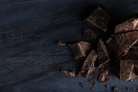 Pieces of dark chocolate on blue marble table, flat lay. Space for textの写真素材