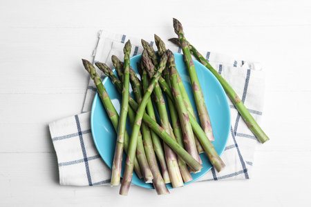 Fresh raw asparagus on white table, flat layの写真素材