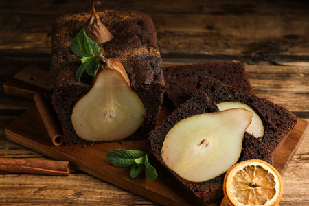 Tasty pear bread with mint, cinnamon and dried orange slices on wooden table. homemade cakeの写真素材