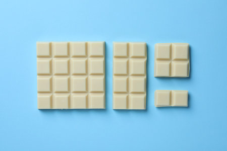 Tasty white chocolate on light blue background, flat layの写真素材