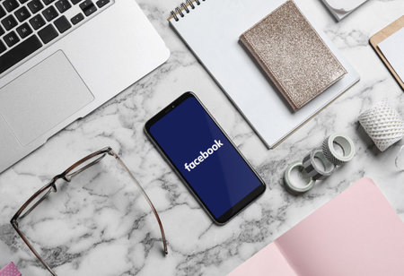 MYKOLAIV, UKRAINE - APRIL 30, 2020: Smartphone with Facebook app on table, flat lay. social media siteのeditorial素材
