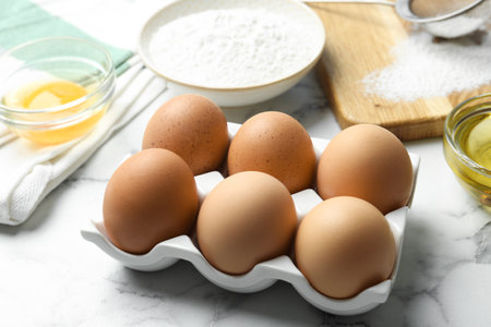 Brown chicken eggs on white marble table