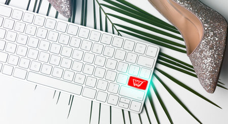 Flat lay composition of modern computer keyboard with cart symbol on white table. internet shopping