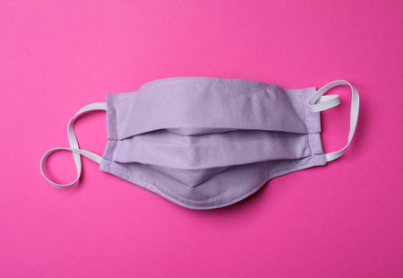 Homemade protective mask on pink background, top view. Sewing ideasの写真素材