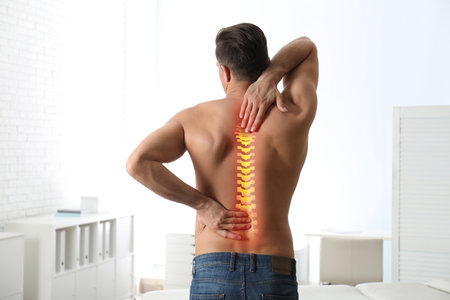 Man suffering from pain in back at clinicの写真素材