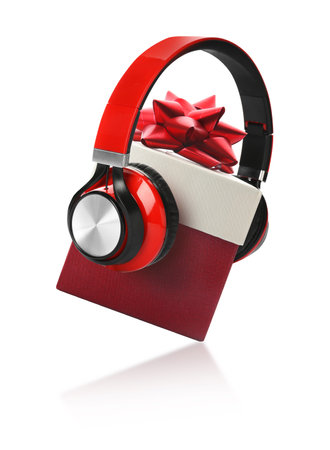 Beautiful Christmas gift box with bow and headphones on white backgroundの写真素材