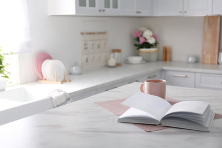 Book and cup on white marble table in modern kitchen. interior designの写真素材