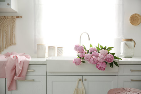 Bouquet of beautiful pink peonies in kitchen sinkの写真素材