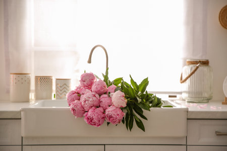 Bouquet of beautiful pink peonies in kitchen sinkの写真素材