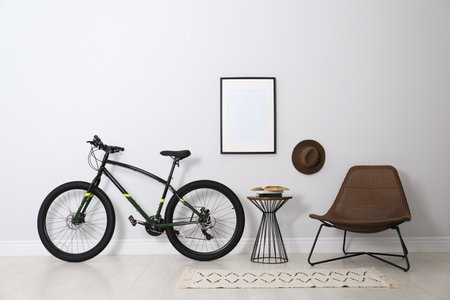 Modern bicycle and comfortable armchair in stylish living room interiorの写真素材