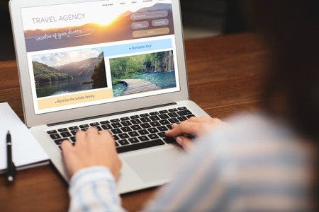 Woman using laptop to plan trip, closeup. travel agency websiteの写真素材
