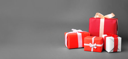 Beautiful gift boxes with ribbons and space for text on gray background. banner design