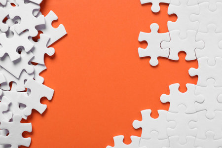 Blank white puzzle pieces on orange background, flat layの写真素材