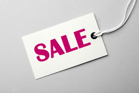 Tag with text SALE on light background, top view. Black Friday