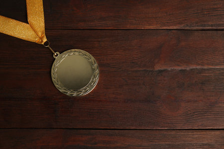 Gold medal on wooden background, top view. space for designの写真素材