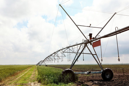 Modern irrigation system in field under cloudy sky. agricultural equipmentの写真素材