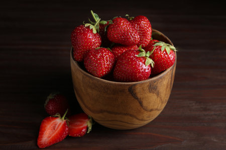 Delicious ripe strawberries in bowl on wooden table, closeupの写真素材