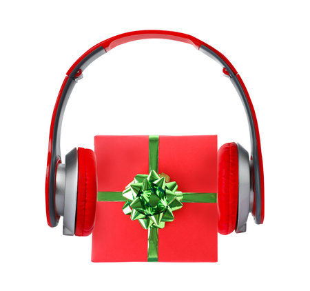 Beautiful Christmas gift box with bow and headphones on white background, top viewの写真素材