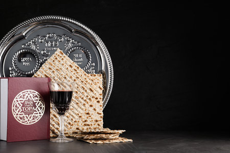 Symbolic Pesach (Passover Seder) items on black table, space for text