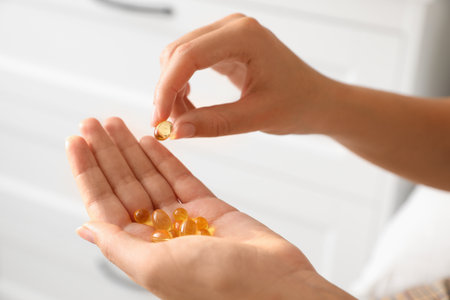 African-American woman with vitamin capsules at home, closeupの写真素材