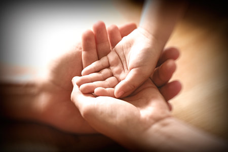 Happy family holding hands on wooden background, closeupの写真素材