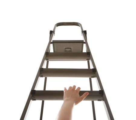 Woman climbing up stepladder against white background, closeupの写真素材