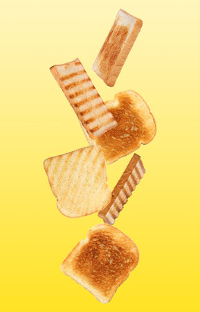 Tasty toasts falling on color background