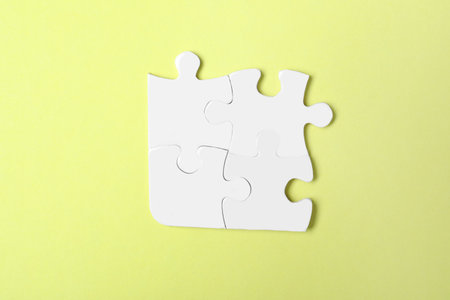 Blank white puzzle pieces on yellow background, top viewの写真素材