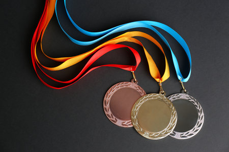 Gold, silver and bronze medals on black background, flat lay. Space for designの写真素材