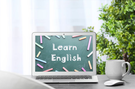 Modern laptop for online English learning on table indoorsの写真素材