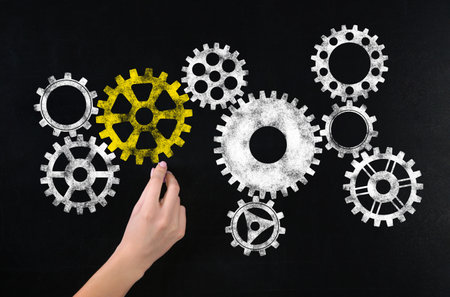 Woman drawing gear mechanism on chalkboard, closeupの写真素材