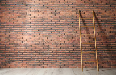 Modern wooden ladder near brick wall. Space for textの写真素材