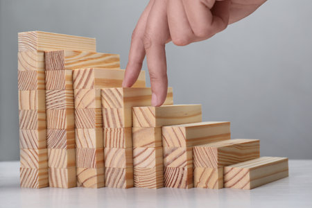 Woman imitating stepping up on wooden stairs with her fingers, closeup. Career ladder