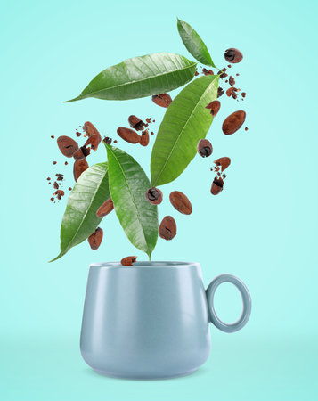 Cocoa beans and leaves falling into cup on turquoise backgroundの写真素材