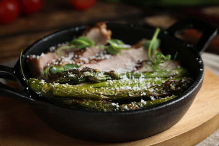 Tasty meat served with asparagus and sprouts in portioned frying pan on table, closeupの写真素材