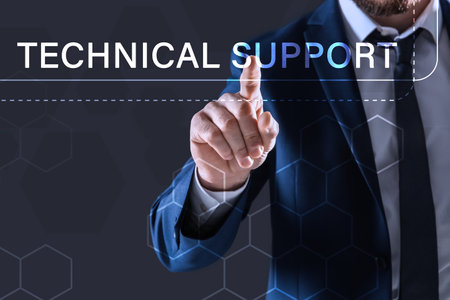 Businessman using virtual screen against dark background, closeup. technical support service