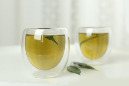 Aromatic green tea and leaves on white tableの写真素材