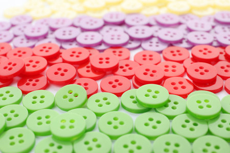 Many colorful plastic sewing buttons as background, closeup
