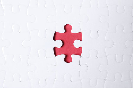 Blank white puzzle with missing piece on red background, top viewの写真素材