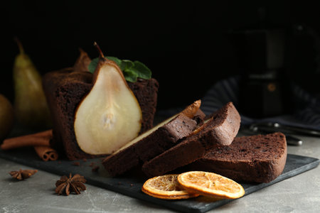 Tasty pear bread with spices, dried orange slices and mint on gray table. homemade cakeの写真素材