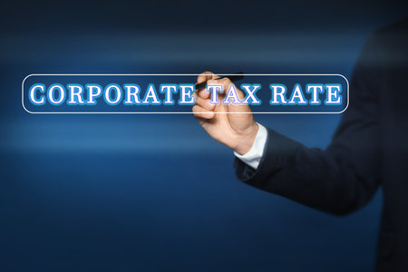 corporate tax rate. Man writing on virtual screen against color background, closeupの写真素材