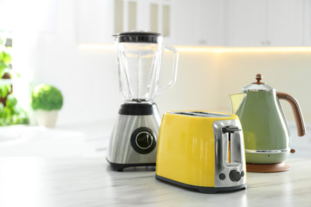 Set of modern home appliances on white marble table in kitchenの写真素材