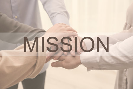 People holding hands together on light background, closeup. mission concept