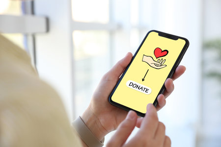 Donations concept. Woman with smartphone indoors, closeupの写真素材