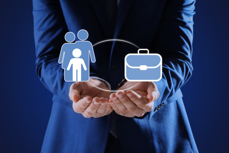 Man holding virtual icons against blue background, closeup. Concept of balance between life and workの写真素材